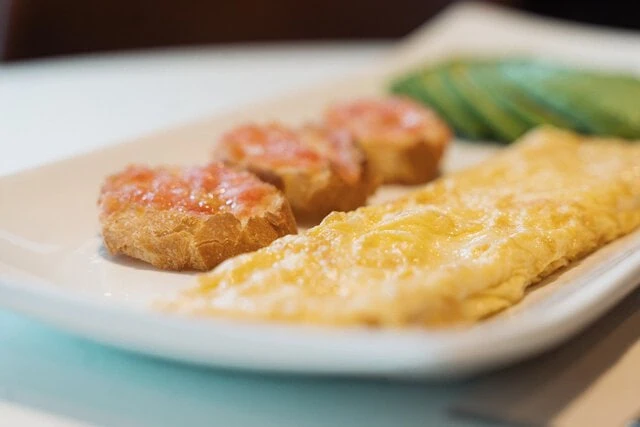 Desayuno de tortilla, pan con tomate y aguacate