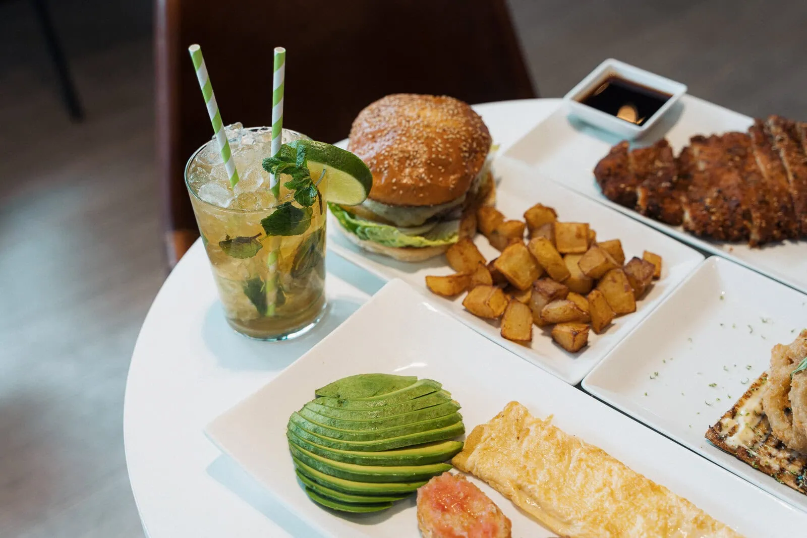Mesa con burger, patatas, tortilla y cóctel en ERREKA